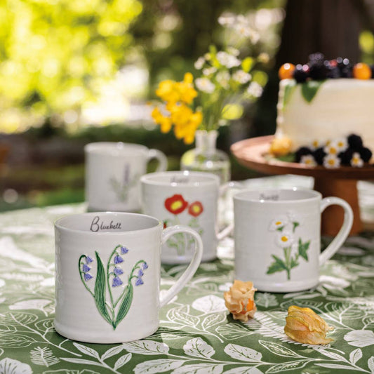 Set of mugs with floral designs on a table outdoors