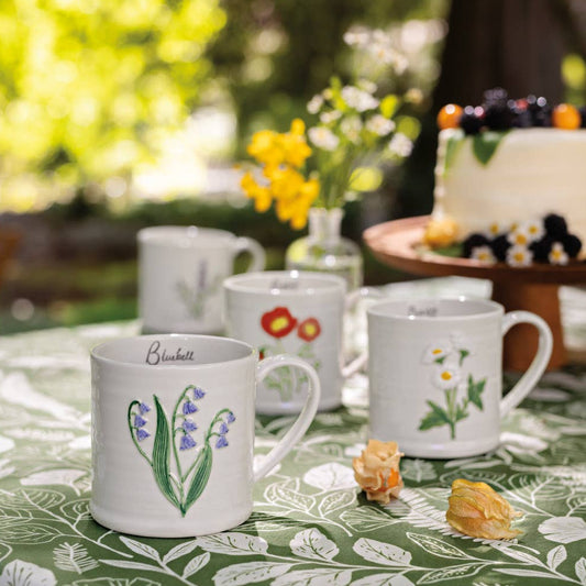 Set of mugs with floral designs on a table outdoors