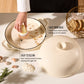 Beige ceramic dish with lid on a light surface, hand cleaning inside the dish.