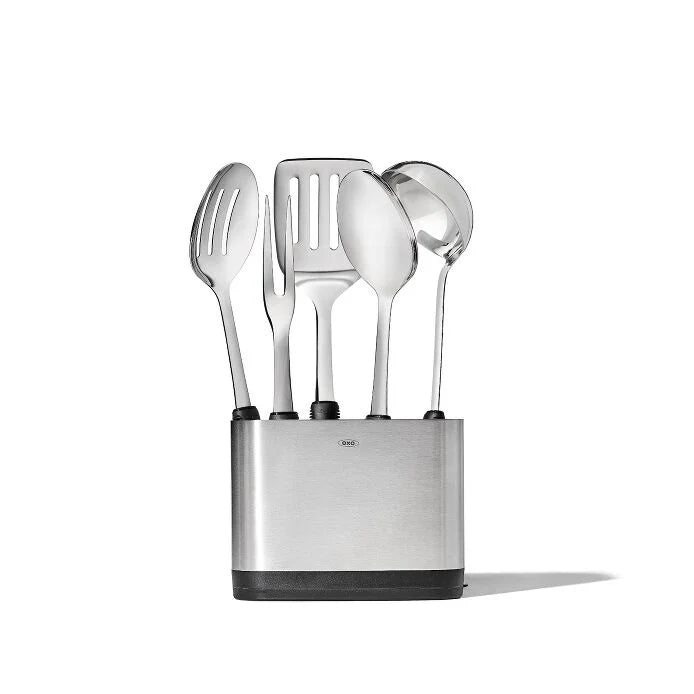 This shiny squad of stainless steel superheroes is ready to tackle everything from Tuesday's quick stew to your famous Sunday roast with style and comfort. The all-star lineup includes a Turner (the pancake-flipping champion), a Spoon (the stirring specialist), a Slotted Spoon (the liquid-draining wizard), a Ladle (the soup-serving expert), a Fork (the meat-wrangling pro), and their stylish home base - the Utensil Holder! 
