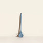 Blue silicone pasta server on a beige background