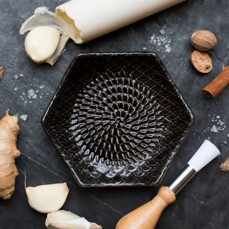 The Grate Plate is a ceramic grating plate used to grate garlic, ginger, peppers, nutmeg, chocolate, hard cheeses and much more! Perfect for adding fresh flavor to any dish. It's easy to clean and can be reused for an endless variety of culinary creations. Plus, the handy silicone garlic peeler and gathering brush make prepping fast and mess-free!