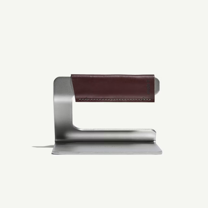 Metallic stand with a brown leather strip on a white background