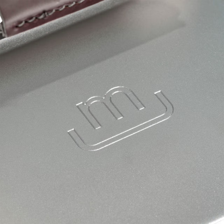 Close-up of a gray surface with a logo embossed on it, likely from a brand.