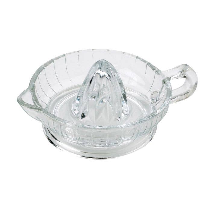 Clear glass manual juicer on a white background