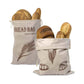 Two bread bags with printed designs filled with bread on a white background