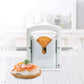 Bread with cream cheese and salmon on a white surface, with a bread slicer in the foreground.