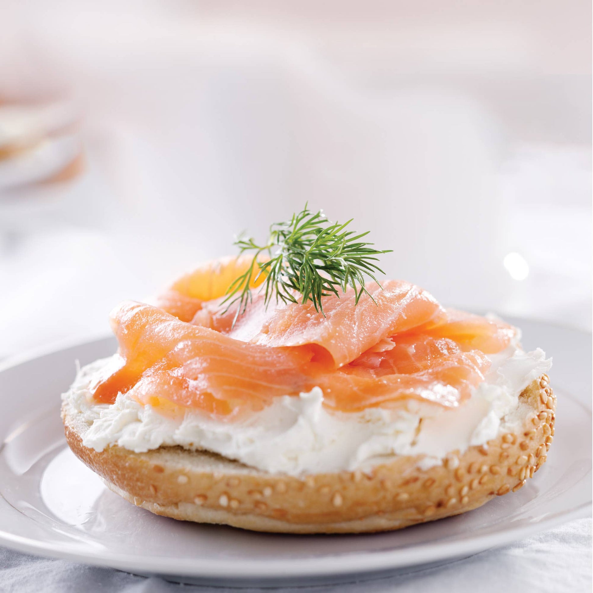 Bagel with cream cheese and smoked salmon on a white plate