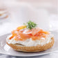 Bagel with cream cheese and smoked salmon on a white plate