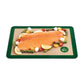 Cut fish and vegetables on a green silicone baking mat on a white background