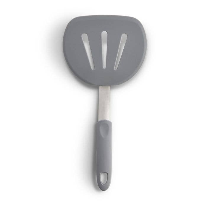 Gray slotted spatula with a white background