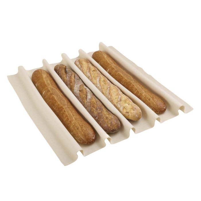 Set of four baguettes in a white bread holder on a white background