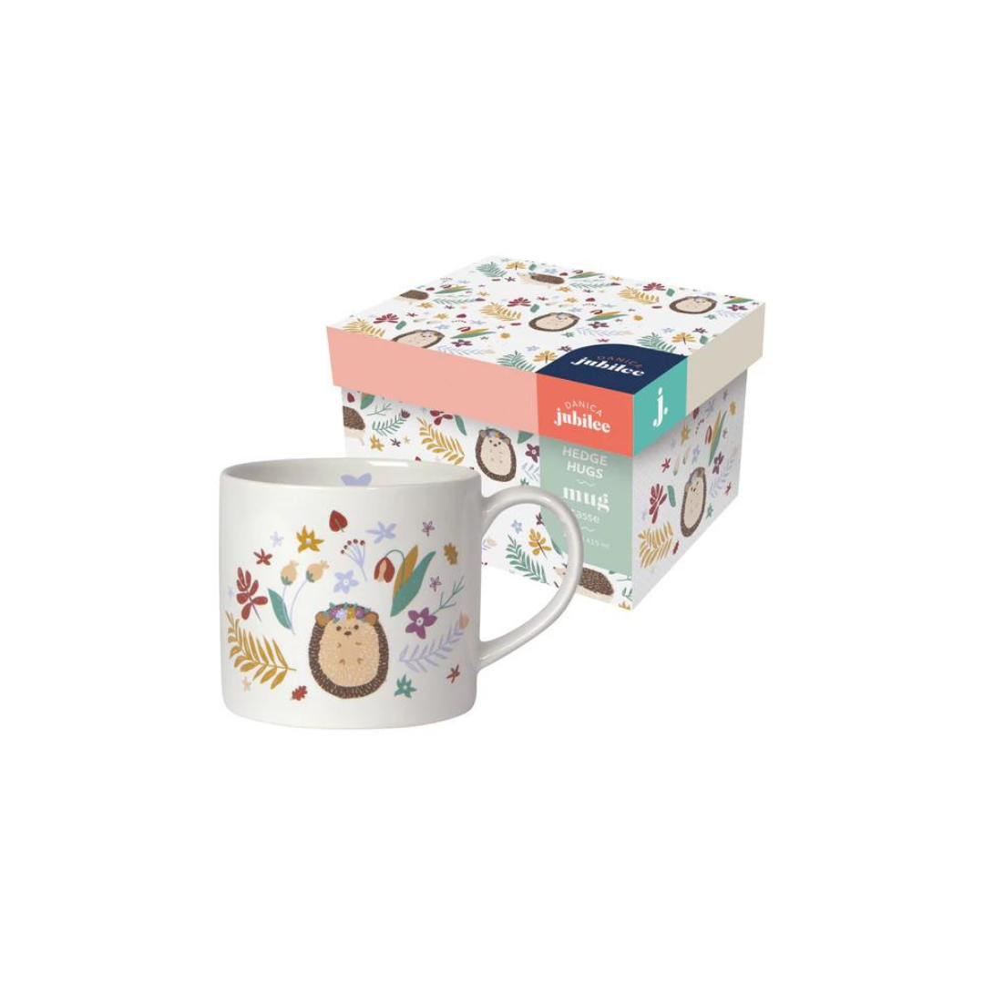  "Hedge Hugs" Mug in a Box brings a cozy, nature-inspired charm to your mornings. Featuring a whimsical hedgehog surrounded by wildflowers and a smooth white interior, 