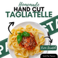 Promotional graphic for handmade hand cut tagliatelle pasta, showing a plate of pasta with tomato sauce, cheese, and basil, with text reading 'Homemade HAND CUT TAGLIATELLE', 'From Scratch', and 'Sold Per Person'.