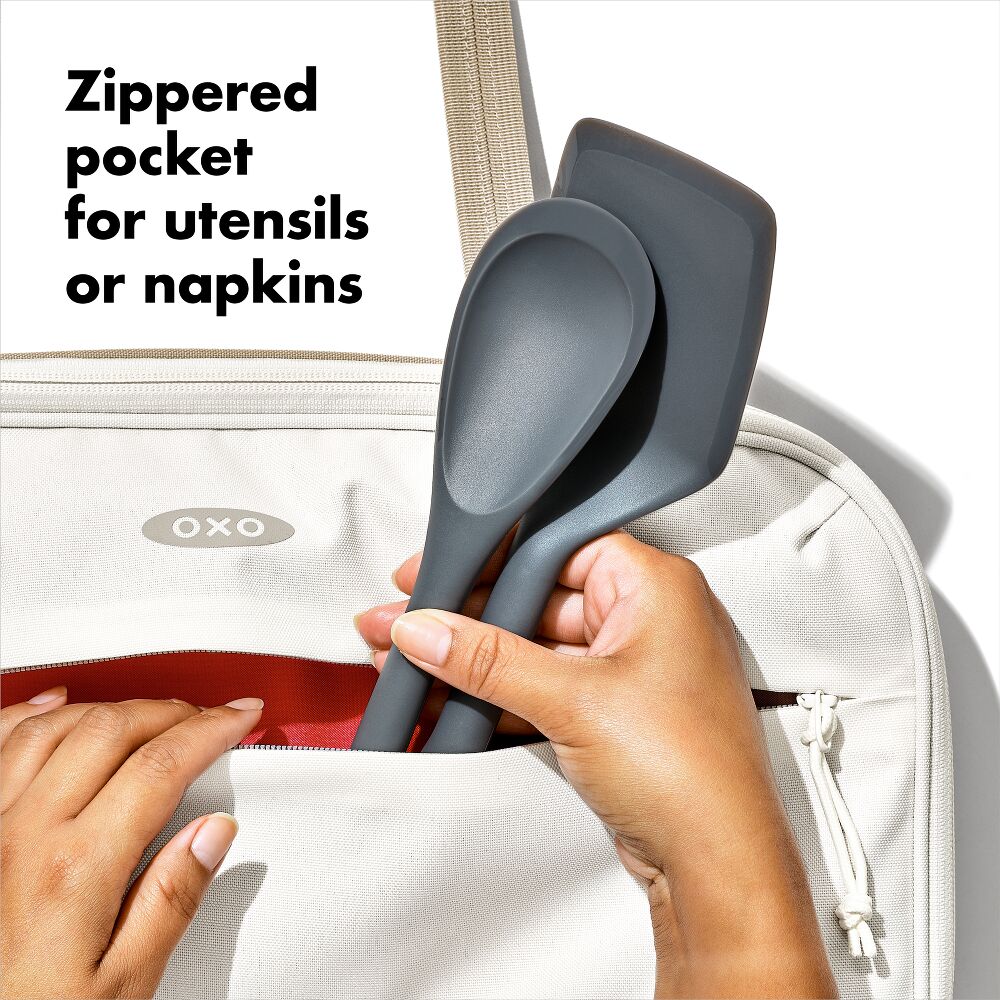 hands adding tools to zippered picket of insulated bakeware carrier