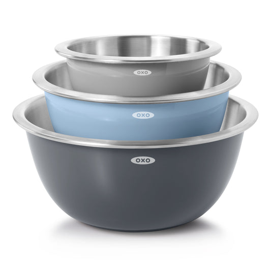 Set of three OXO stainless steel mixing bowls in gray, blue, and black on a white background