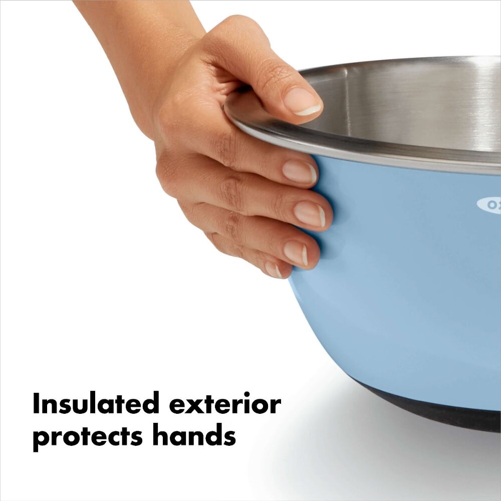 Hand holding blue mixinb bowl showing an insulated exterior. 