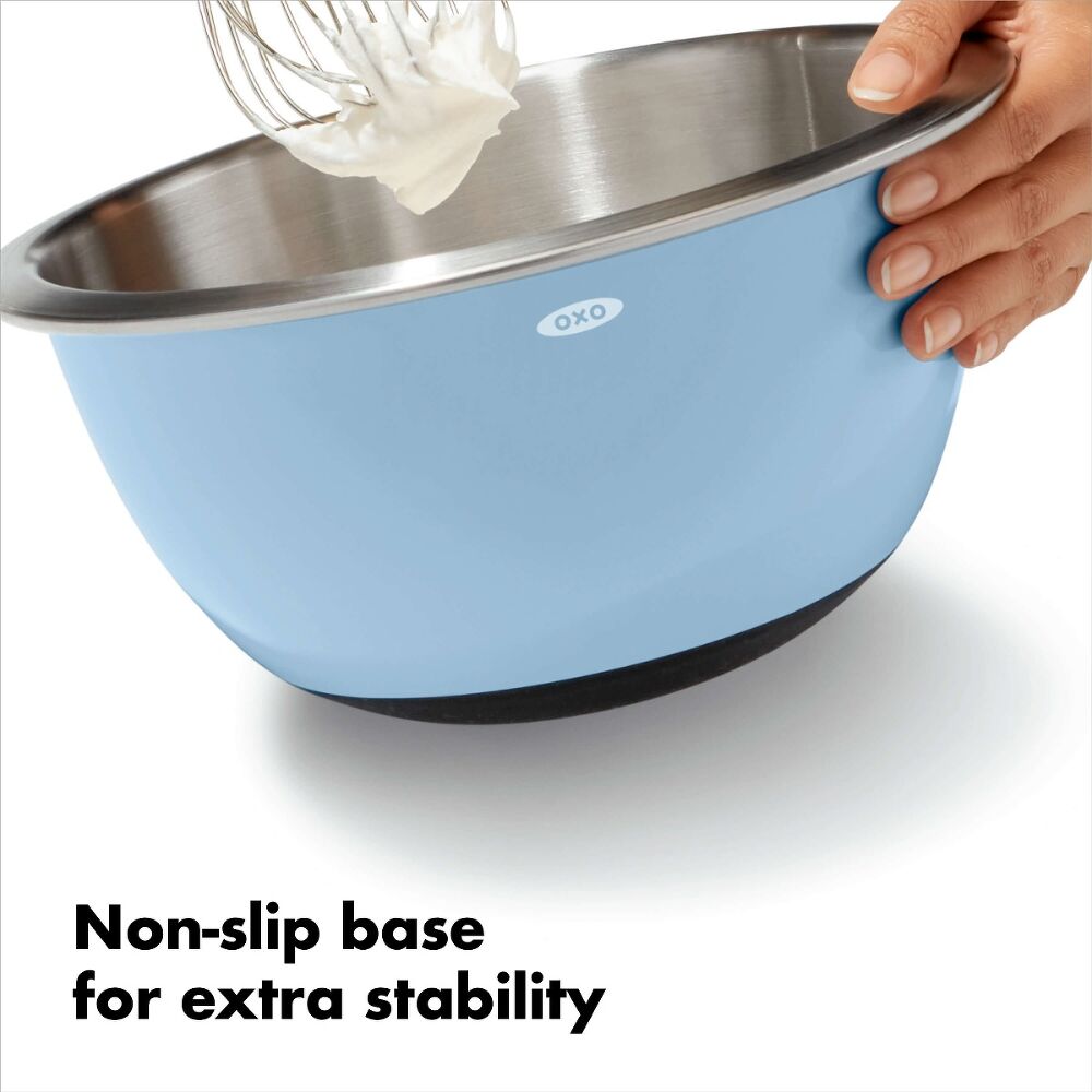 Hand using blue insulated mixing bowl showing a non slip base. 