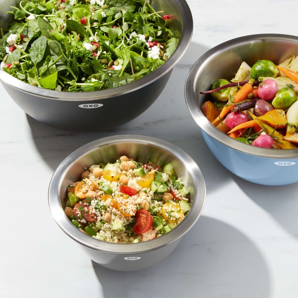 Set of 3 mixing bowls holding salad ingredients. 
