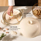 Beige ceramic dish with lid on a light surface, hand cleaning inside the dish.