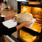 Person placing a ceramic dish with a lid into an oven, with text about the dish's features.