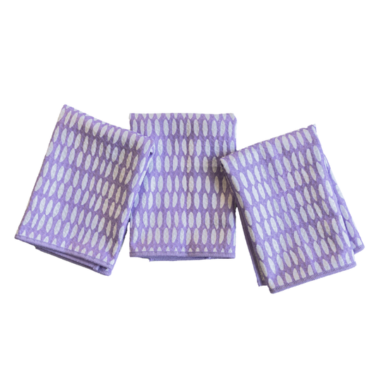 Three folded purple towels with white patterns on a white background