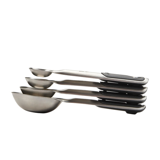 Set of stainless steel measuring spoons on a white background