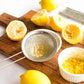 Strainer with lemon seeds, lemons on a cutting board