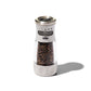 OXO pepper grinder with black peppercorns on a white background