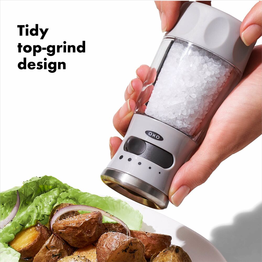 Hand holding tidy top grind design salt grinder. 