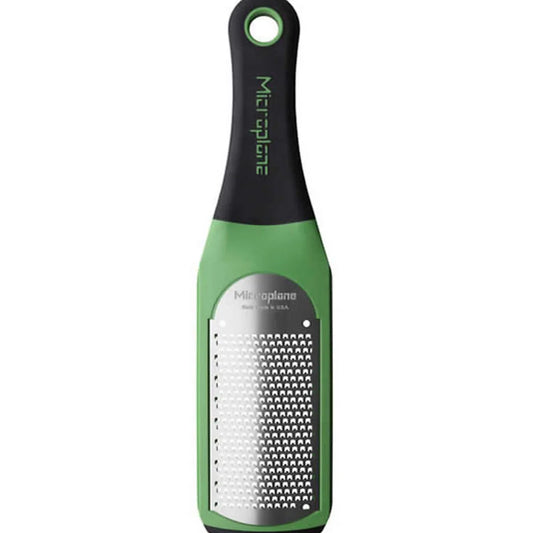 Green and black Microplane grater on a white background