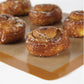 Cinnamon rolls on a silicone baking mat with a white background