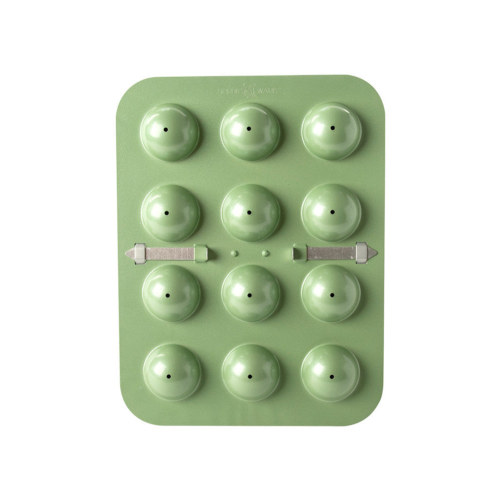Green silicone mold with spherical cavities on a white background
