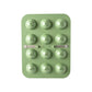 Green silicone mold with spherical cavities on a white background