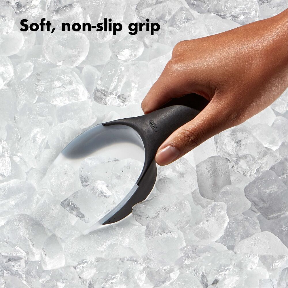 Hand holding a black ice scraper on a background of ice cubes with text 'Soft, non-slip grip'.