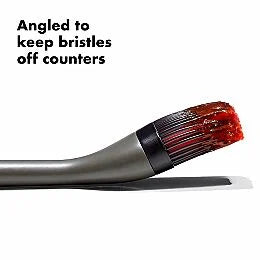 Cleaning brush with bristles angled to avoid counters on a white background