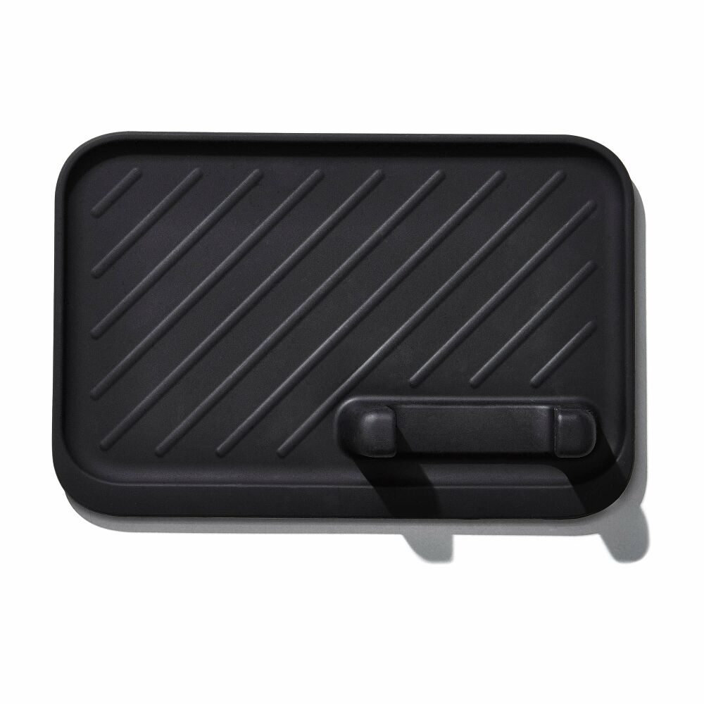 Black grill tool rest with handle on a white background
