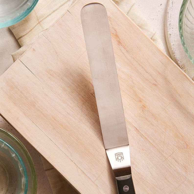 Offset Spatula with a black handle on a wooden cutting board