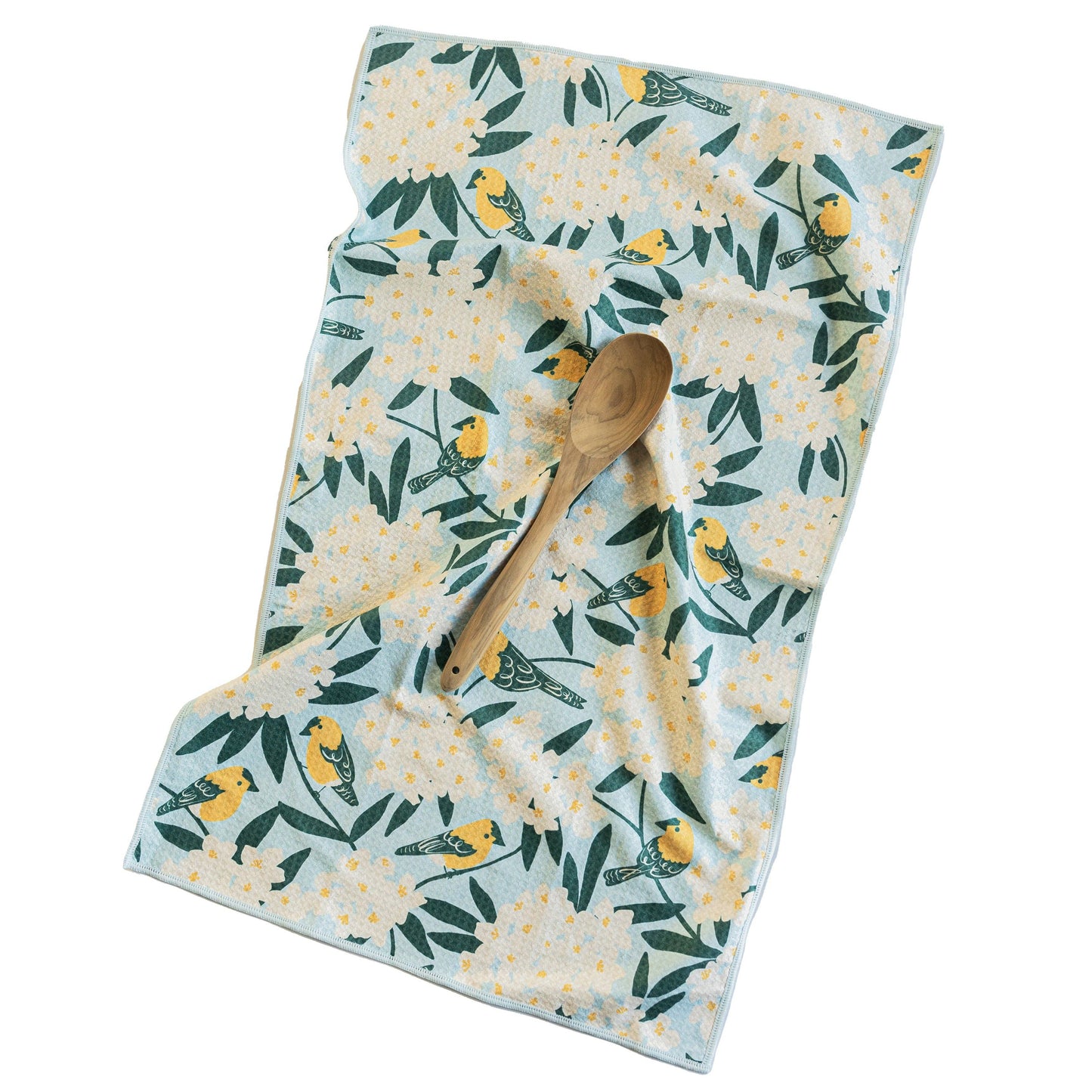 Floral patterned towel with a wooden spoon on a white background