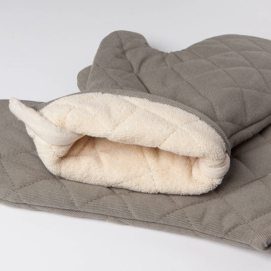 Gray quilted oven mitt with white interior on a light gray background