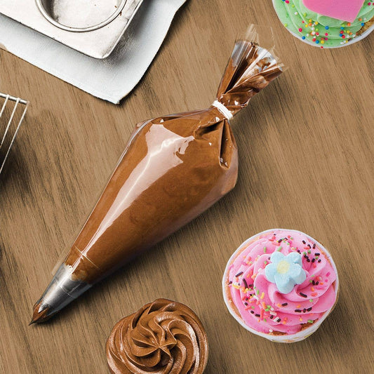 Chocolate icing bag, decorated cupcake, and piping tip on a wooden surface