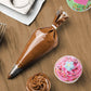 Chocolate icing bag, decorated cupcake, and piping tip on a wooden surface