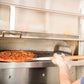 Person taking a pizza out of an oven using a peel.