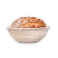 Loaf of bread in a round, woven basket on a white background