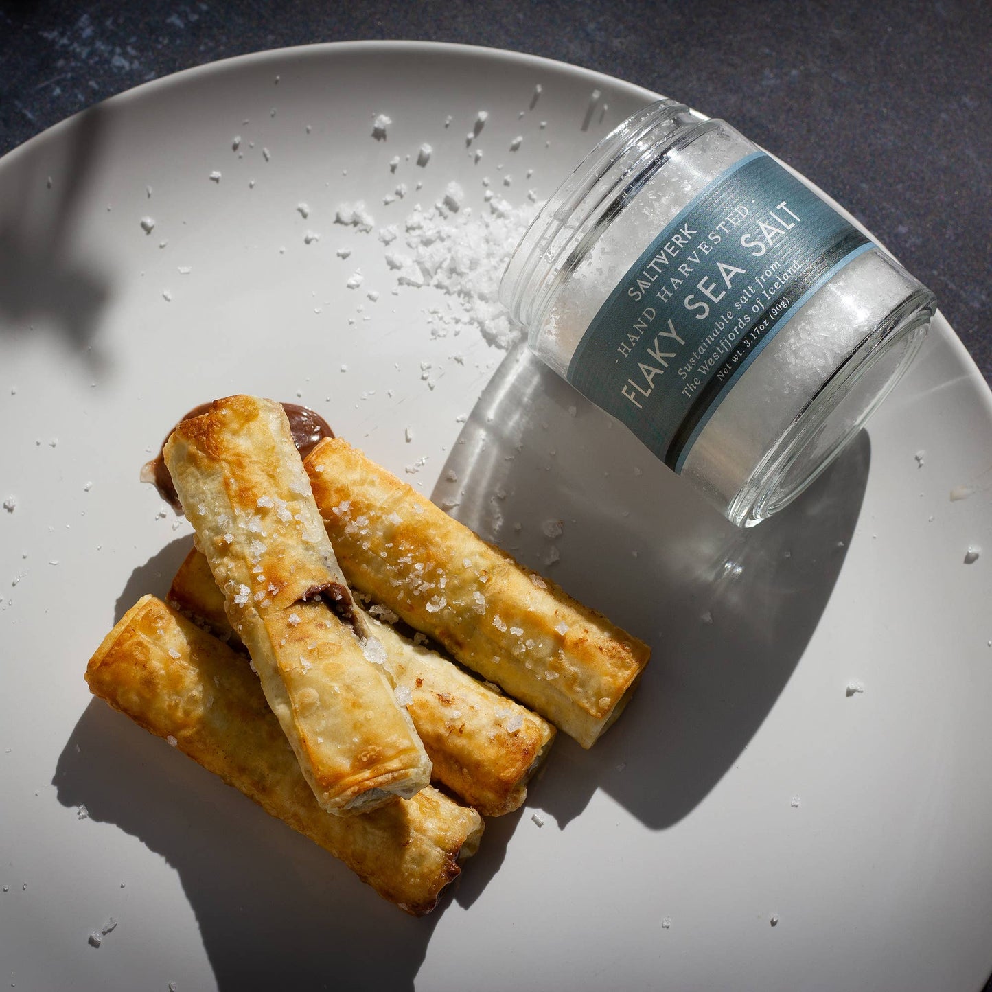 Pastry rolls with flaky sea salt on a plate