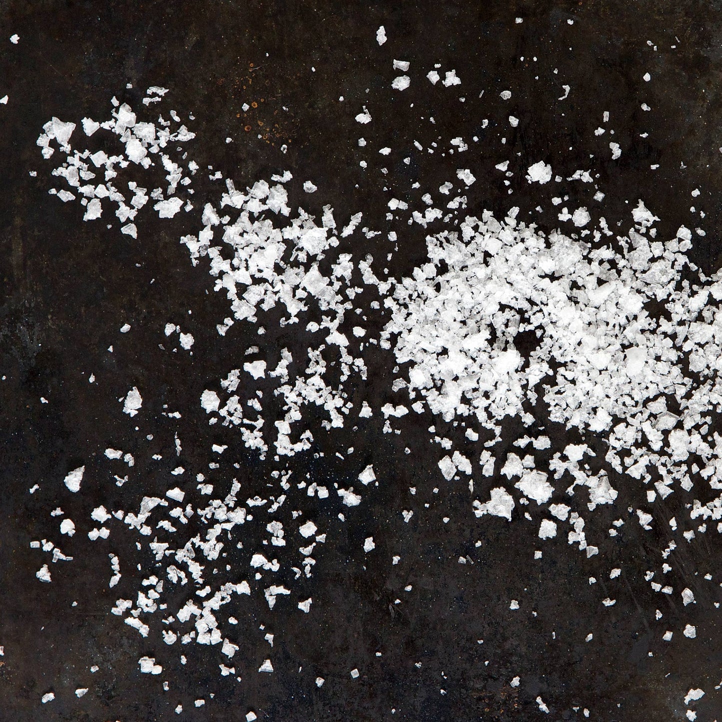 White salt crystals on a dark surface