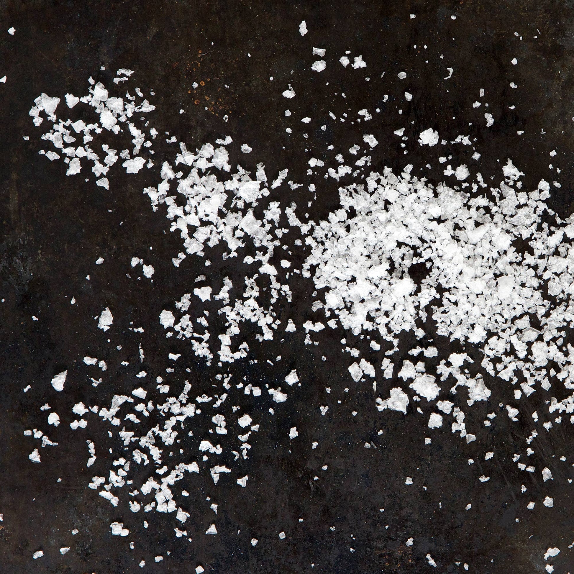 White salt crystals on a dark surface