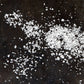 White salt crystals on a dark surface