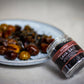 Jar of Sautwerk Lava Salt with a plate of roasted vegetables in the background