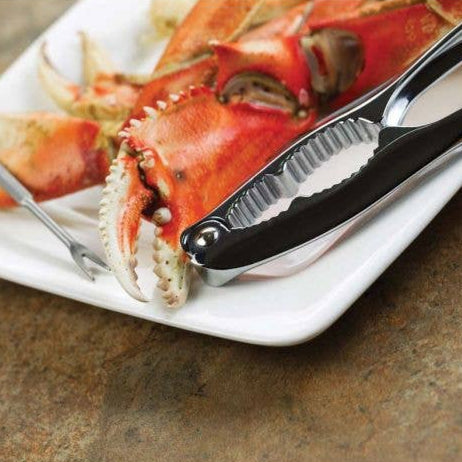 Seafood Crackerand pick on a white plate with a crab letg on a brown surface